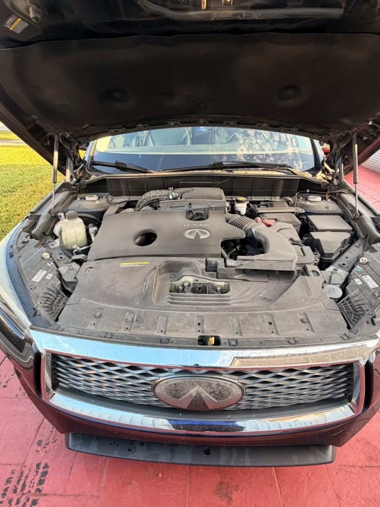 Infiniti front with open hood showing dusty VC-Turbo engine bay